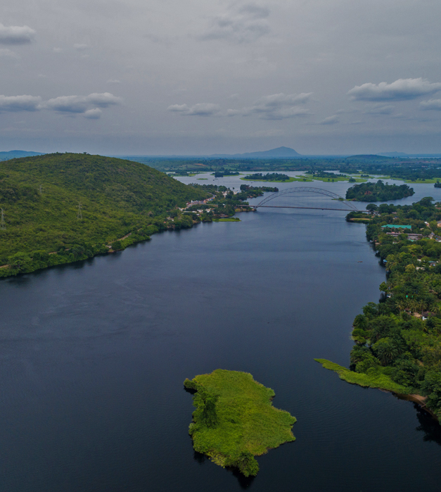 An aerial view of the beautiful and iconic Adomi Bridge and Volta River surrounded by greenery and nature in Ghana