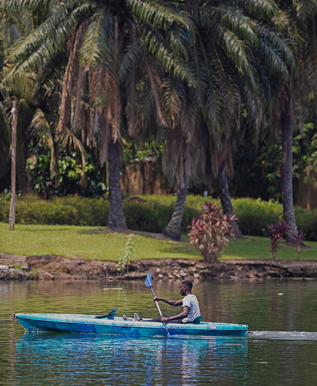 Photo of a guest kayaking on the Volta River in front of The Royal Senchi Hotel & Resort in Ghana