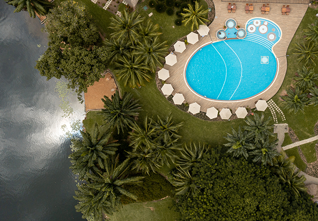 Aerial view of the swimming pool and the landscape at The Royal Senchi Hotel & Resort next to the Volta River in Ghana